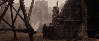 Movie still from “Willow” (1988), directed by Ron Howard – A group of people standing next to each other in front of a building; Wide shot, Low angle