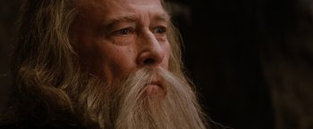Movie still from “Willow” (1988), directed by Ron Howard – An old man with a long white beard looking into the distance; Close Up shot, Low angle