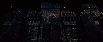 Movie still from “Willow” (1988), directed by Ron Howard – A castle like building with a dark sky in the background at night; Extreme Wide shot, Low angle