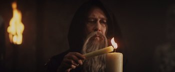 Movie still from “Willow” (1988), directed by Ron Howard – An old man lighting a candle in a dark room; Close Up shot, Low angle