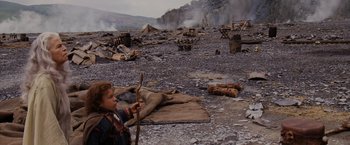 Movie still from “Willow” (1988), directed by Ron Howard – A young boy holding a stick in a field; Wide shot, High angle