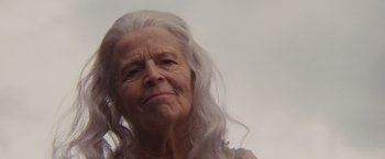 Movie still from “Willow” (1988), directed by Ron Howard – An older woman with long white hair looking at the camera; Close Up shot, Low angle