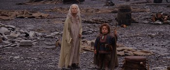 Movie still from “Willow” (1988), directed by Ron Howard – A woman and a boy standing next to each other on rocks; Medium shot, Low angle