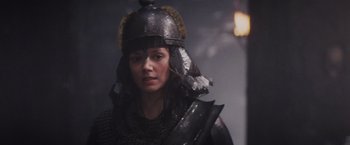 Movie still from “Willow” (1988), directed by Ron Howard – A woman wearing a helmet and armor in a dark room; Close Up shot, Over the shoulder angle