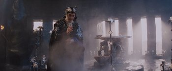 Movie still from “Willow” (1988), directed by Ron Howard – A man dressed as a wizard standing in front of a fountain; Medium shot, High angle