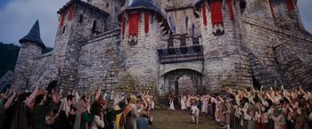 Movie still from “Willow” (1988), directed by Ron Howard – A group of people standing in front of a castle; Extreme Wide shot, High angle