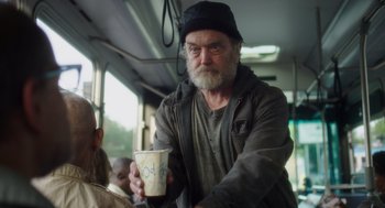 Movie still from “Wilson” (2017), directed by Craig Johnson – An older man holding a cup of coffee on a bus; Medium shot, Over the shoulder angle