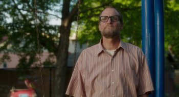 Movie still from “Wilson” (2017), directed by Craig Johnson – A man with a beard and glasses standing in front of a tree; Medium shot, Low angle