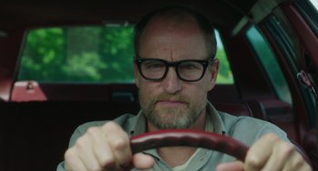 Movie still from “Wilson” (2017), directed by Craig Johnson – A man with a beard wearing glasses driving a car; Close Up shot, Low angle