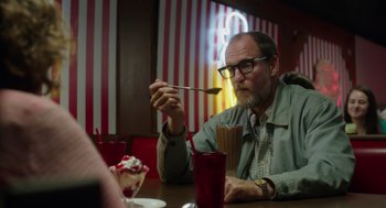 Movie still from “Wilson” (2017), directed by Craig Johnson – A man sitting at a table with a spoon in his mouth; Medium shot, Over the shoulder angle