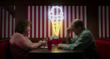 Movie still from “Wilson” (2017), directed by Craig Johnson – A man and a woman sitting at a table in front of an ice cream sign; Medium shot, Over the shoulder angle