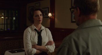 Movie still from “Wilson” (2017), directed by Craig Johnson – A woman wearing a black tie sitting in front of a man; Medium shot, Over the shoulder angle