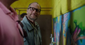 Movie still from “Wilson” (2017), directed by Craig Johnson – A man with glasses standing in front of a mural; Close Up shot, Over the shoulder angle