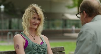 Movie still from “Wilson” (2017), directed by Craig Johnson – A woman sitting on top of a wooden park bench; Close Up shot, Over the shoulder angle