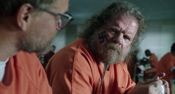 Movie still from “Wilson” (2017), directed by Craig Johnson – A man in an orange shirt with a nazi symbol painted on his face; Close Up shot, Over the shoulder angle