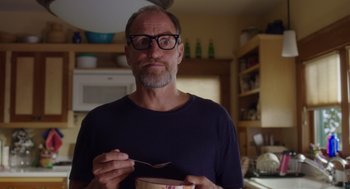Movie still from “Wilson” (2017), directed by Craig Johnson – A man with glasses is eating a bowl of cereal; Close Up shot, Over the shoulder angle