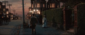 Movie still from “Winchester” (2018), directed by Michael Spierig – A group of people walking down a street at night; Wide shot, High angle