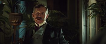 Movie still from “Winchester” (2018), directed by Michael Spierig – A man in a suit with a mustache; Close Up shot, Low angle