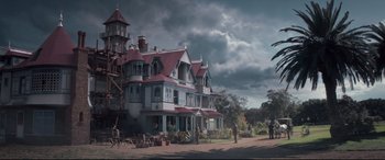 Movie still from “Winchester” (2018), directed by Michael Spierig – A painting of people standing in front of an old house; Extreme Wide shot, Low angle