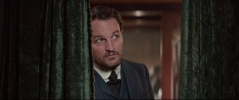 Movie still from “Winchester” (2018), directed by Michael Spierig – A person wearing a suit and tie; Close Up shot, Over the shoulder angle