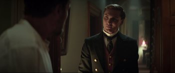 Movie still from “Winchester” (2018), directed by Michael Spierig – A man in a suit looking at himself in a mirror; Close Up shot, Over the shoulder angle