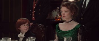 Movie still from “Winchester” (2018), directed by Michael Spierig – A woman sitting at a table in front of a man; Medium shot, Over the shoulder angle