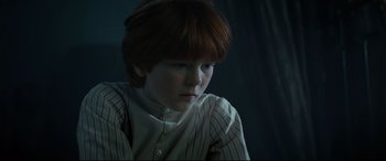 Movie still from “Winchester” (2018), directed by Michael Spierig – A young boy with red hair and a white shirt; Close Up shot, Low angle