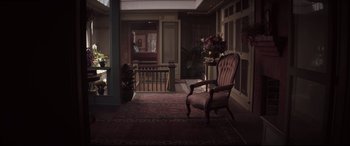 Movie still from “Winchester” (2018), directed by Michael Spierig – An empty room with a chair and a vase of flowers on the floor; Wide shot, High angle