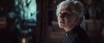 Movie still from “Winchester” (2018), directed by Michael Spierig – An older woman with white hair looking into the distance; Close Up shot, Over the shoulder angle