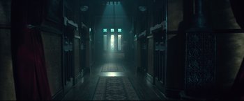 Movie still from “Winchester” (2018), directed by Michael Spierig – A dark hallway with a light shining on it; Extreme Wide shot, Low angle