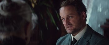 Movie still from “Winchester” (2018), directed by Michael Spierig – A person wearing a suit and tie; Close Up shot, Over the shoulder angle