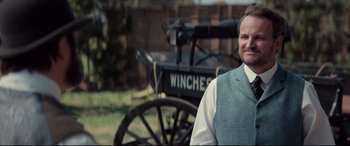 A man standing in front of an old carriage