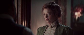 Movie still from “Winchester” (2018), directed by Michael Spierig – A woman with red hair wearing a green jacket; Close Up shot, Over the shoulder angle