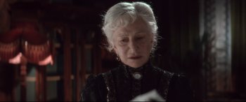 Movie still from “Winchester” (2018), directed by Michael Spierig – An older woman with white hair wearing a black dress; Close Up shot, Over the shoulder angle