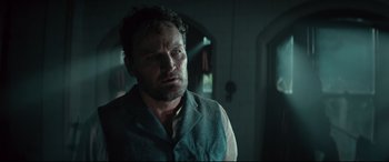 Movie still from “Winchester” (2018), directed by Michael Spierig – A person wearing a vest; Close Up shot, Low angle