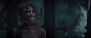 Movie still from “Winchester” (2018), directed by Michael Spierig – A woman with red curly hair wearing a pink dress; Close Up shot, Low angle