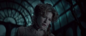 Movie still from “Winchester” (2018), directed by Michael Spierig – A young woman with red curly hair wearing a white dress; Close Up shot, Low angle