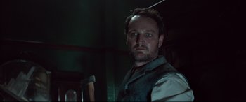 Movie still from “Winchester” (2018), directed by Michael Spierig – A person holding a hammer in a room; Close Up shot, Low angle