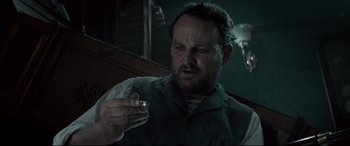 Movie still from “Winchester” (2018), directed by Michael Spierig – A man holding a cigarette in his hand; Close Up shot, Low angle