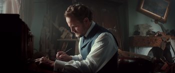 Movie still from “Winchester” (2018), directed by Michael Spierig – A man writing on a piece of paper with a pen; Medium shot, Low angle