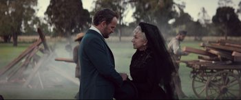 Movie still from “Winchester” (2018), directed by Michael Spierig – An older man and woman holding hands in a park; Medium shot, Over the shoulder angle