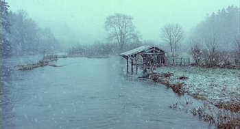 Movie still from “Winged Migration” (2001), directed by Jacques Cluzaud – A snowy day with a river and a bridge; Extreme Wide shot, High angle