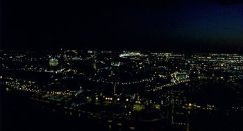 Movie still from “Winged Migration” (2001), directed by Jacques Cluzaud – A view of a city at night from a hill; Extreme Wide shot, High angle