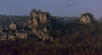 Movie still from “Winged Migration” (2001), directed by Jacques Cluzaud – A flock of birds flying over a rocky cliff; Extreme Wide shot, High angle
