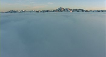 Movie still from “Winged Migration” (2001), directed by Jacques Cluzaud – A view of a mountain range from above the clouds; Extreme Wide shot, High angle