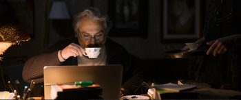 Movie still from “Winter Sleep” (2014), directed by Nuri Bilge Ceylan – An older man sitting at a table with a laptop; Medium shot, High angle