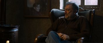 Movie still from “Winter Sleep” (2014), directed by Nuri Bilge Ceylan – An older man sitting in a chair in front of a woman; Medium shot, Over the shoulder angle