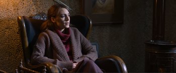 Movie still from “Winter Sleep” (2014), directed by Nuri Bilge Ceylan – A woman sitting in a chair wearing a sweater; Medium shot, Over the shoulder angle