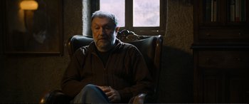 Movie still from “Winter Sleep” (2014), directed by Nuri Bilge Ceylan – An older man sitting in a chair in front of a window; Medium shot, High angle