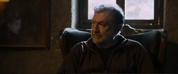 Movie still from “Winter Sleep” (2014), directed by Nuri Bilge Ceylan – An older man sitting in a chair in front of a window; Close Up shot, Over the shoulder angle